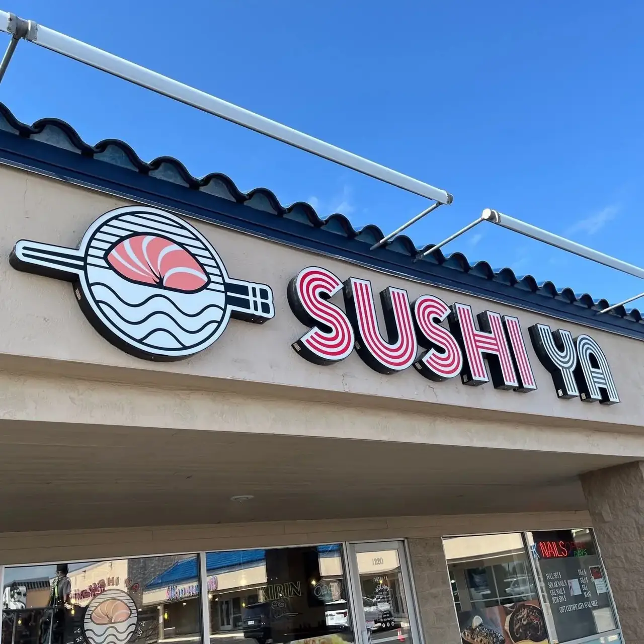 Sushi Ya dimensional lettering and a round sushi illustration installed above a restaurant entrance