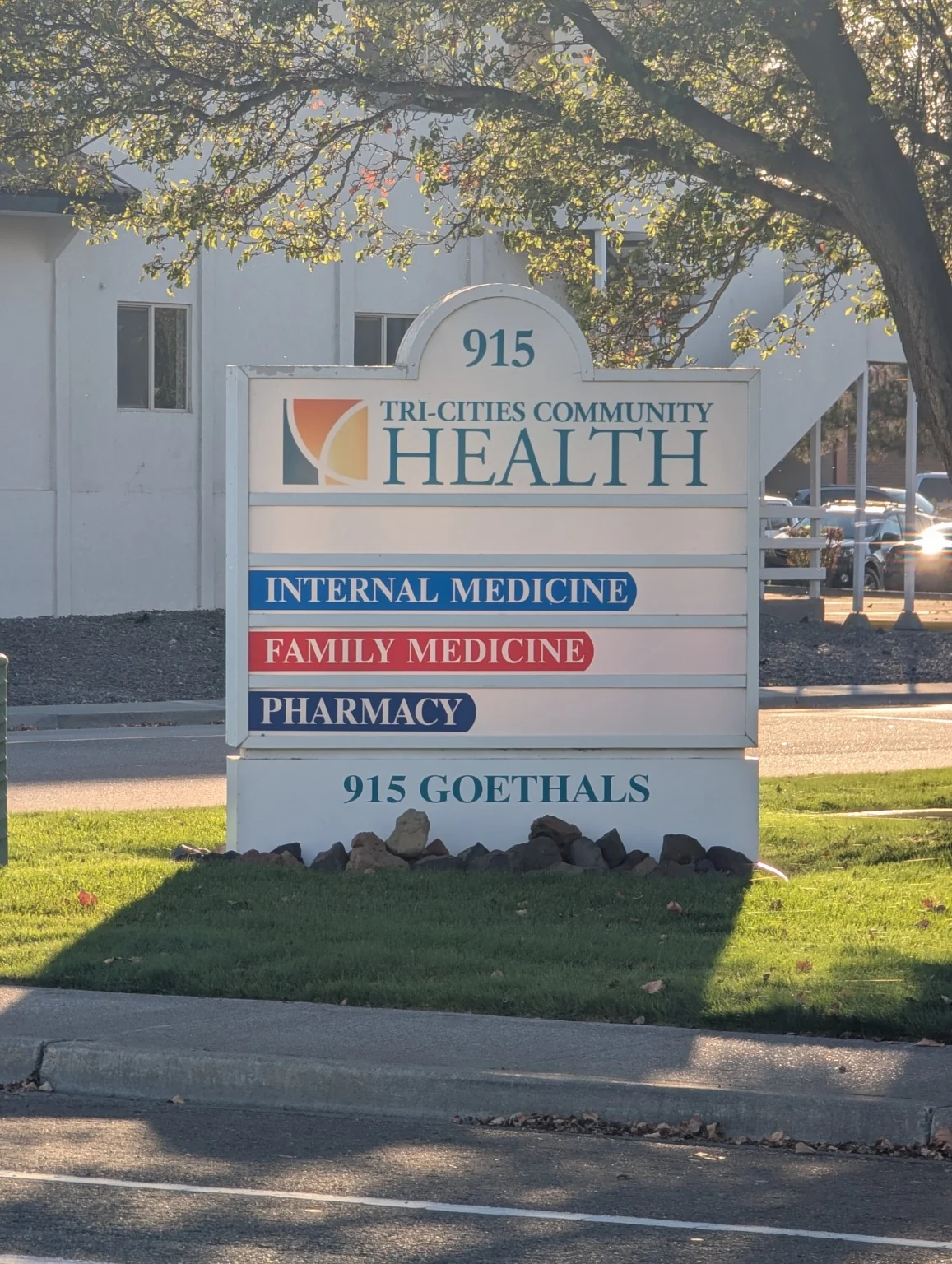 Tri-Cities Community Health monument sign with blue Internal Medicine, red Family Medicine, and dark blue Pharmacy directional bands